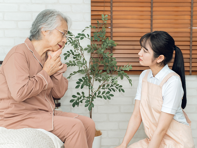 頬を抑える高齢者